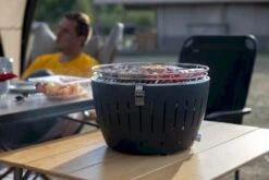 LotusGrill XL Hybrid Houtskoolbarbecue - Rood -Camping Verkoop lotusgrill in gebruik met toppy shirtje 2